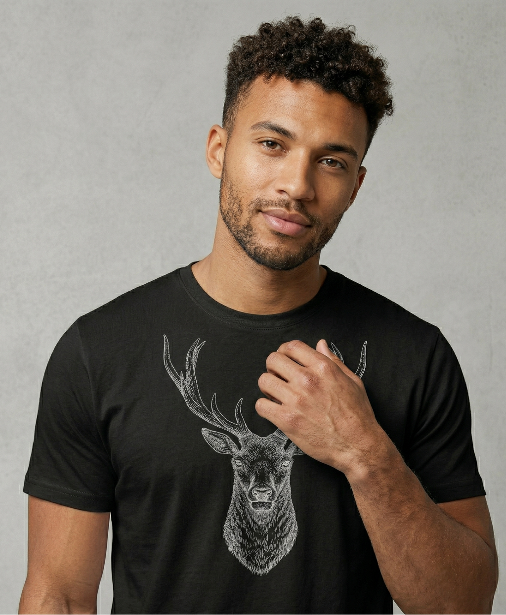 Man wearing a black t-shirt with a deer graphic on a gray background